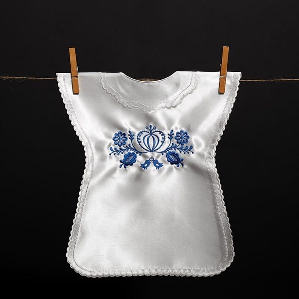 Satin christening gown without a collar, featuring folk embroidery